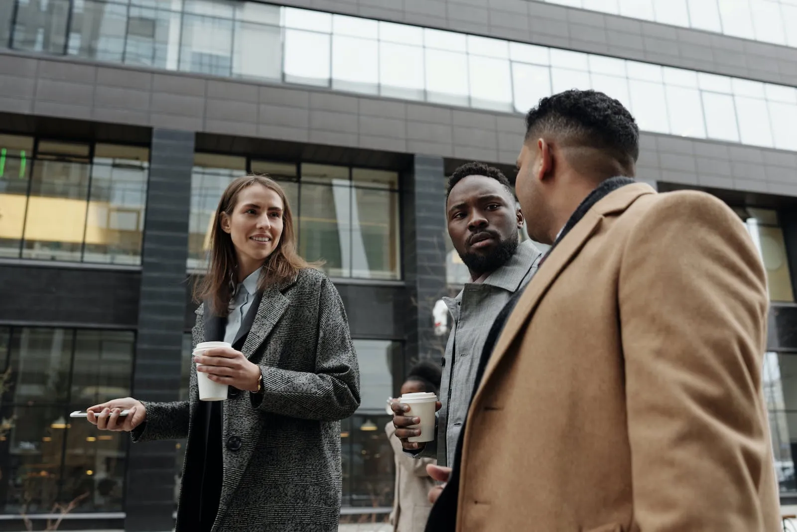 Courtier immobilier Gatineau discutant avec clients potentiels devant immeuble moderne. Valorisation immobilière et vente propriétés par agent immobilier expérimenté Outaouais.